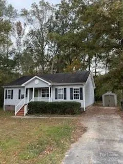 a front view of a house with a garden and trees