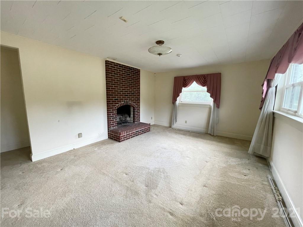 3096 Deal Mill Road Hudson, NC 28638 - Photo 9 of 25 a view of an empty room with a fireplace and a window