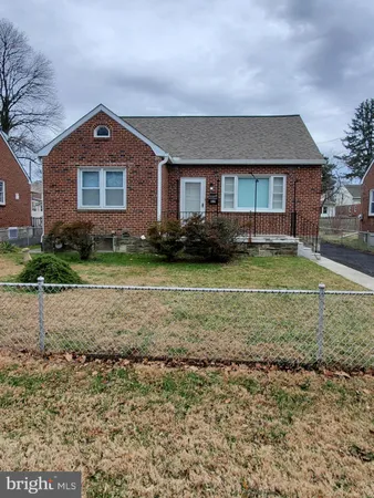 a view of a yard in front of a brick house with large windows