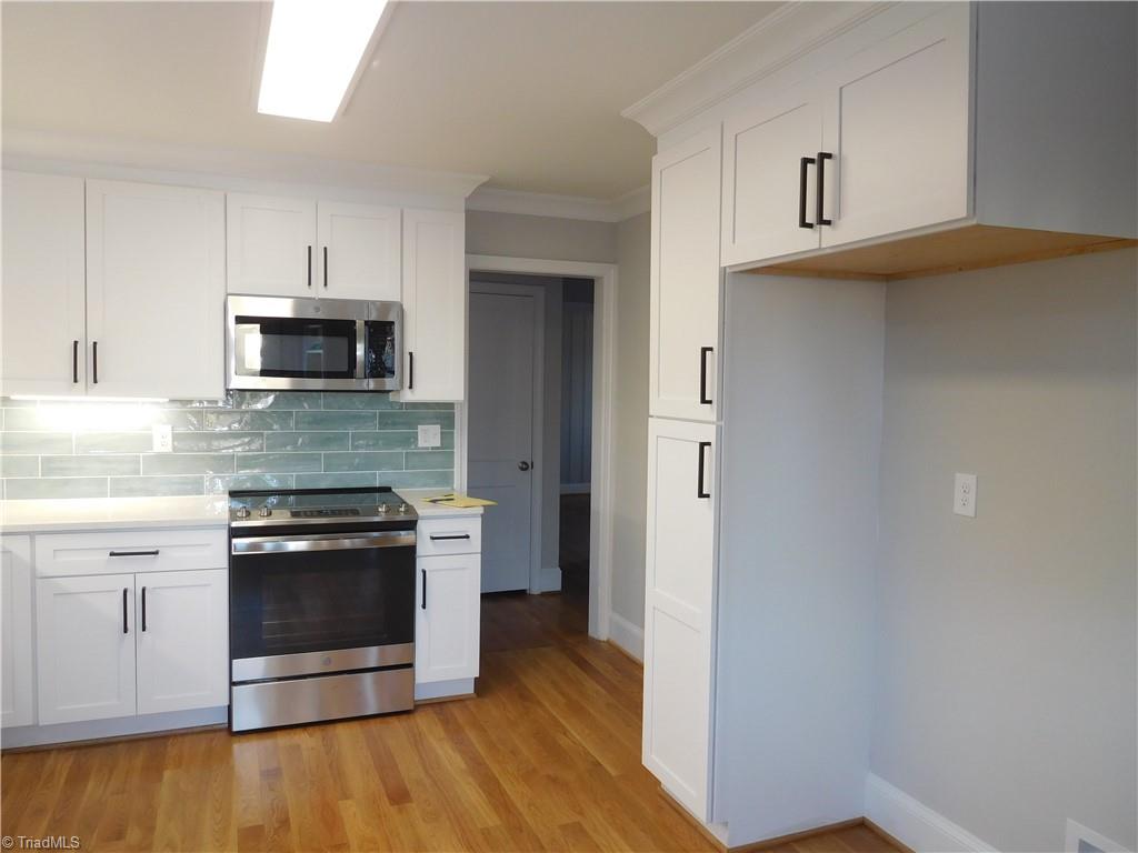 839 Central Road Clemmons, NC 27012 - Photo 9 of 35 Pantry and over Fridge Cabinets for more storage. Hardwoods continue in Kitchen.