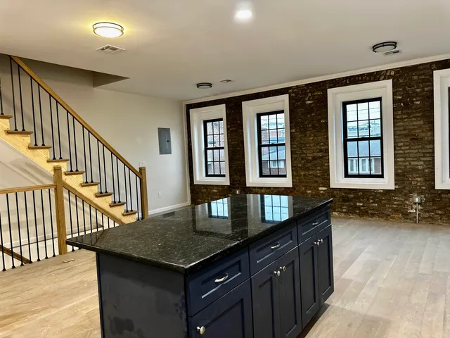 a kitchen with granite countertop a sink and a stove