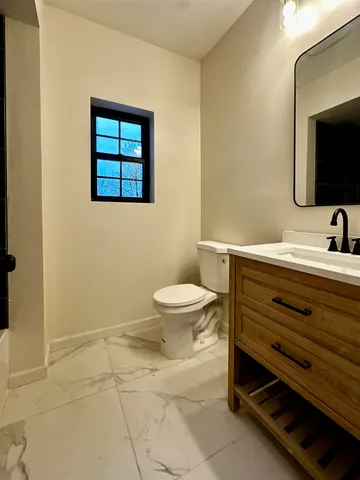 a bathroom with a toilet sink and mirror