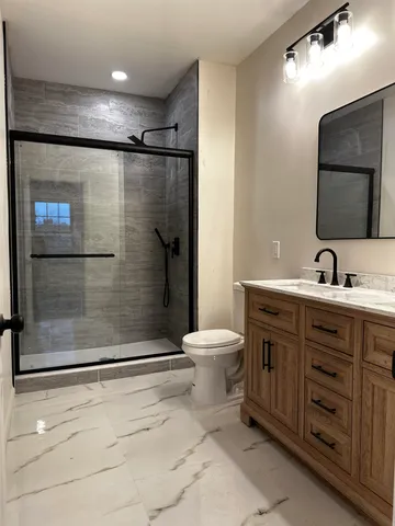 a bathroom with a double vanity sink toilet and shower