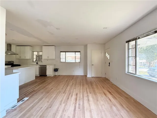 a view of a kitchen with wooden floor and a window