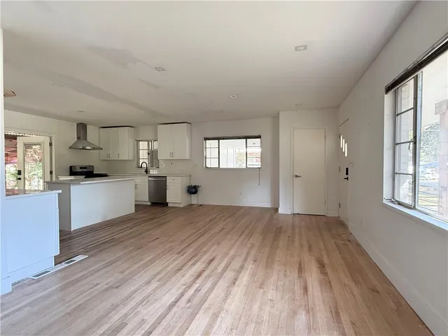 a view of a kitchen with wooden floor and windows