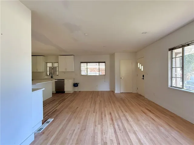 a view of a kitchen with wooden floor and electronic appliances