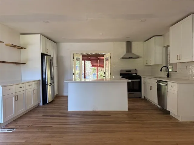 a kitchen with granite countertop a refrigerator stove top oven and sink