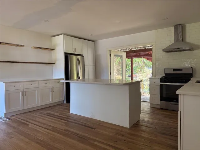 a kitchen with granite countertop white cabinets and wooden floor