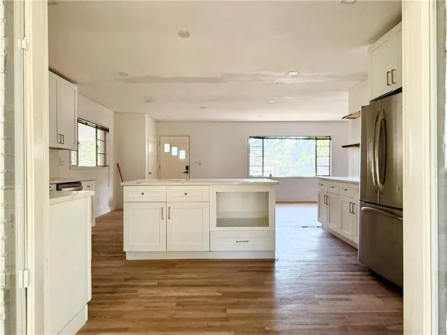 a kitchen with a refrigerator and white cabinets