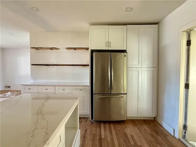 a view of a refrigerator in kitchen and wooden floor