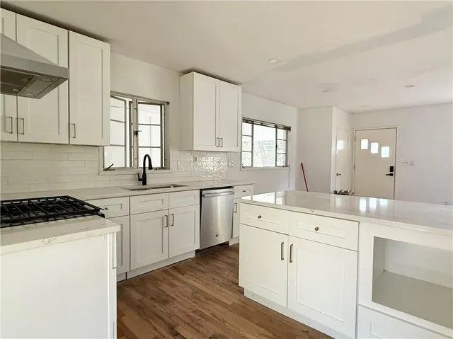 a kitchen that has a sink and a stove in it