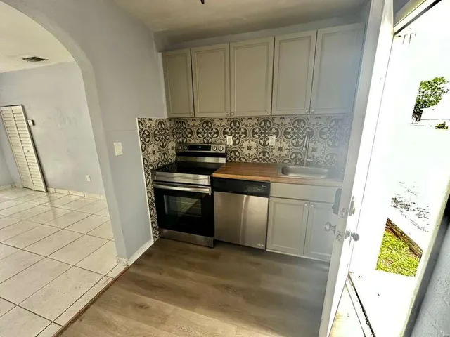 a kitchen with a stove and a white cabinet
