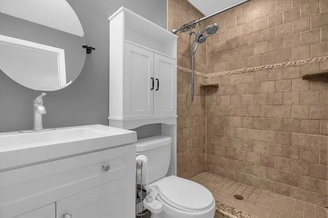 a bathroom with a sink a toilet and shower