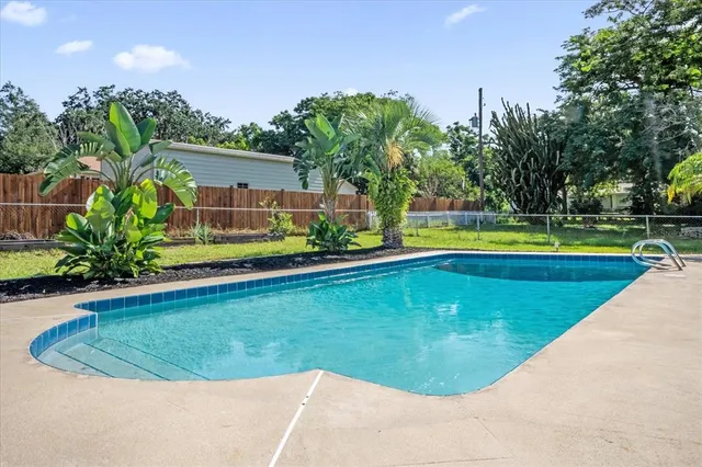 a view of a swimming pool and trees in the background