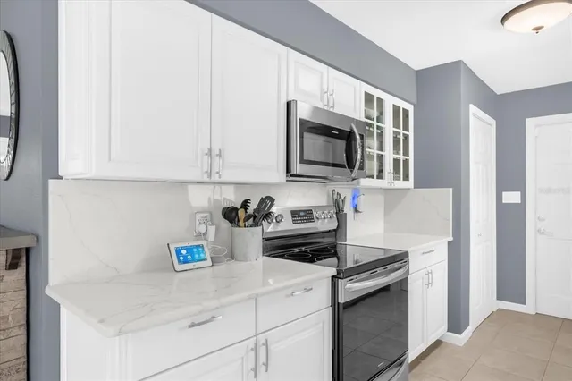 a kitchen with stainless steel appliances granite countertop a sink a stove and a microwave