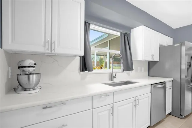 a kitchen with stainless steel appliances white cabinets and a sink