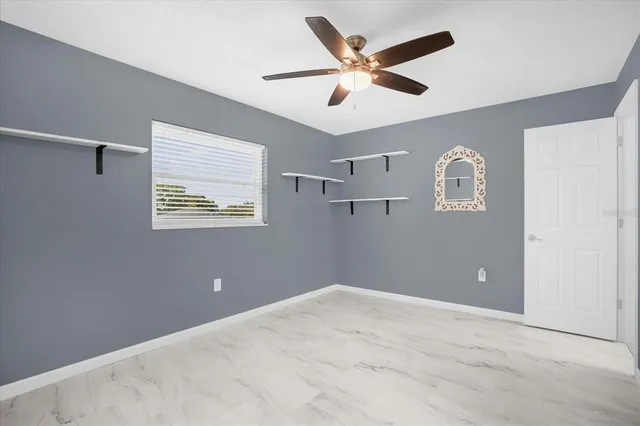 a view of a big room with a ceiling fan and a window