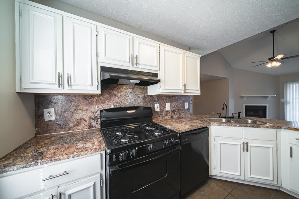 5825 Stafford Lane Columbus, GA 31907 - Photo 12 of 33 a kitchen with granite countertop a stove sink and cabinets