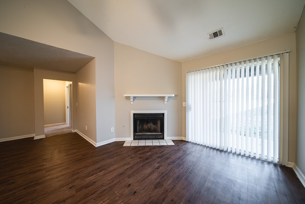5825 Stafford Lane Columbus, GA 31907 - Photo 7 of 33 an empty room with wooden floor fireplace and windows