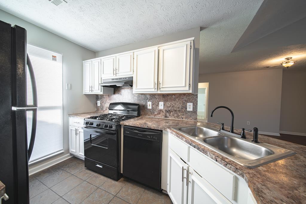 5825 Stafford Lane Columbus, GA 31907 - Photo 10 of 33 a kitchen with granite countertop a sink stove and refrigerator