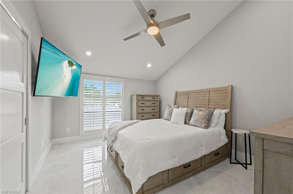 8765 Lateen Lane, Unit 203 Fort Myers, FL 33919 - Photo 12 of 28 a bedroom with a large bed and a flat tv screen on dresser