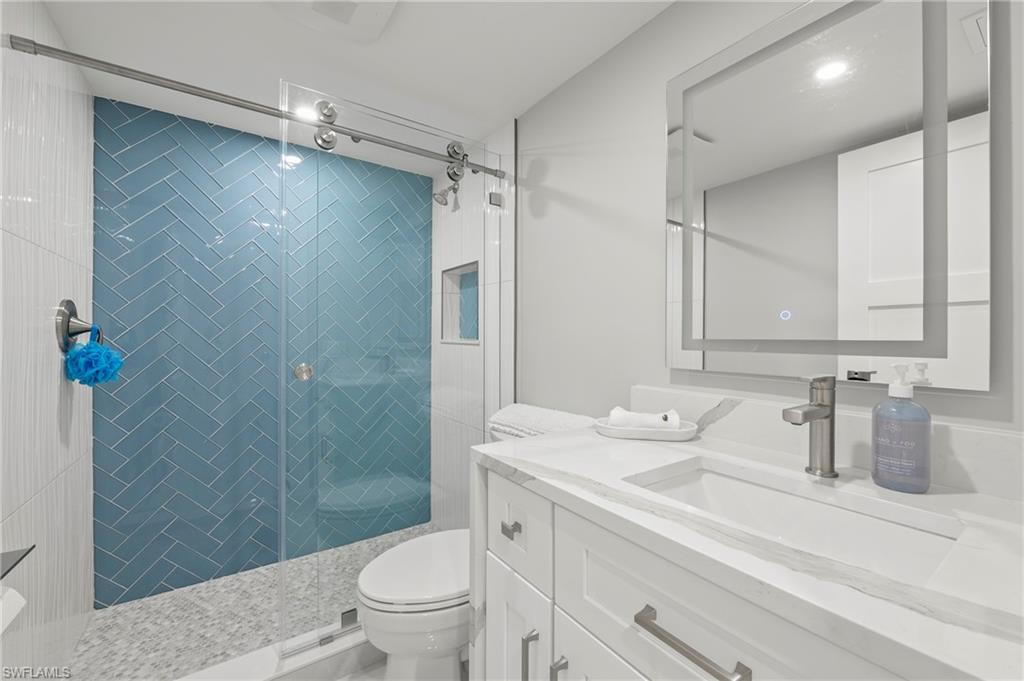 8765 Lateen Lane, Unit 203 Fort Myers, FL 33919 - Photo 13 of 28 a bathroom with a sink a toilet and shower