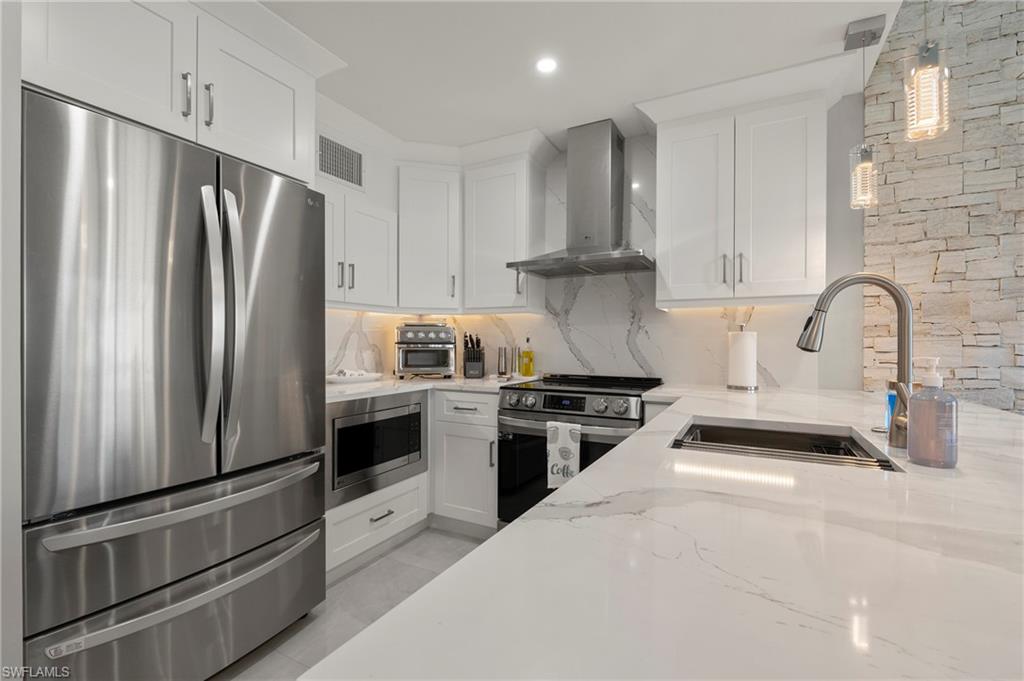 8765 Lateen Lane, Unit 203 Fort Myers, FL 33919 - Photo 8 of 28 a kitchen with stainless steel appliances a refrigerator stove and sink