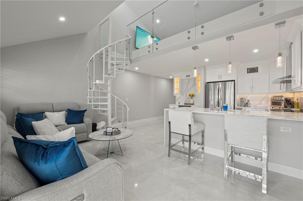 8765 Lateen Lane, Unit 203 Fort Myers, FL 33919 - Photo 10 of 28 a living room with furniture and kitchen view