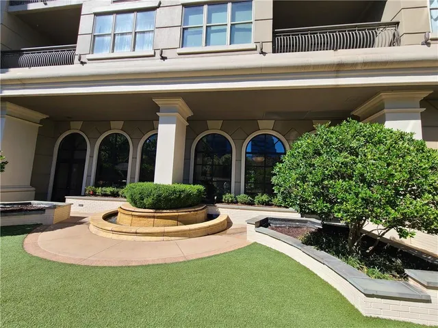 a view of a patio with table and chairs potted plants and floor to ceiling window