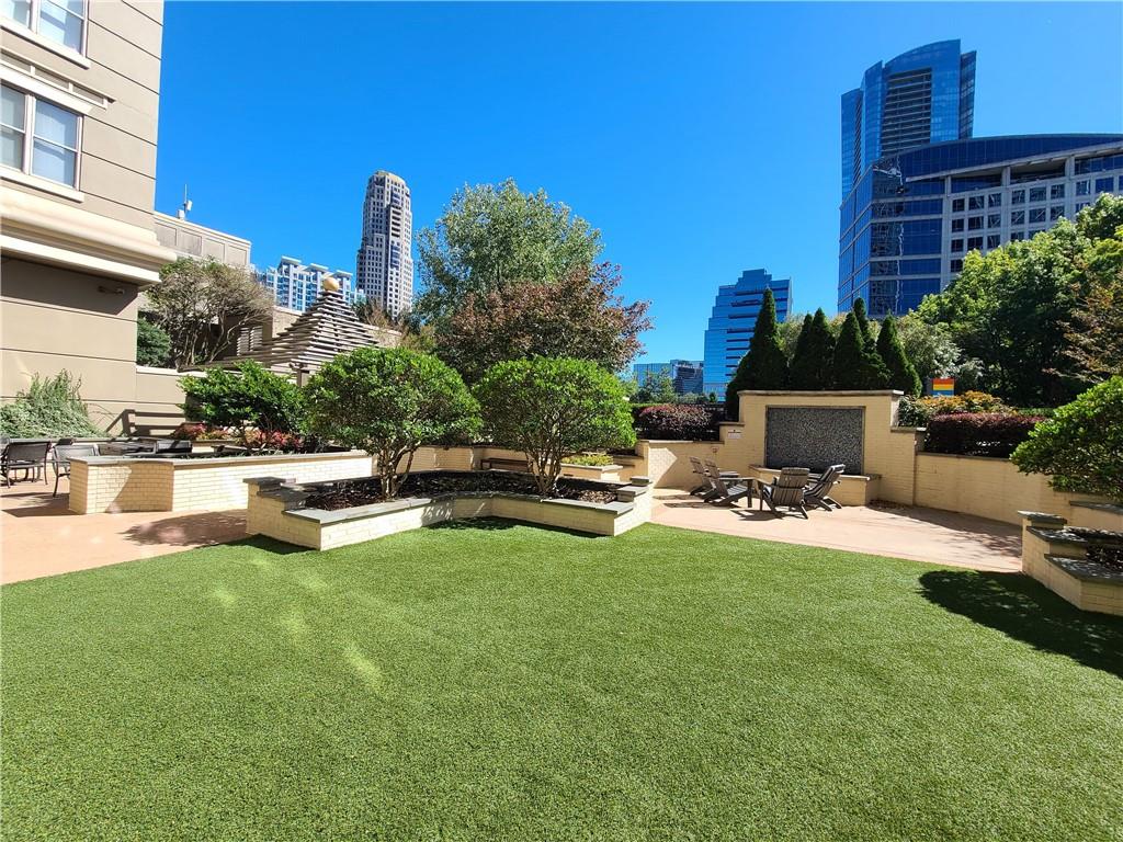3334 Peachtree Road Northeast, Unit 910 Atlanta, GA 30326 - Photo 2 of 35 a view of a swimming pool with a patio and a yard