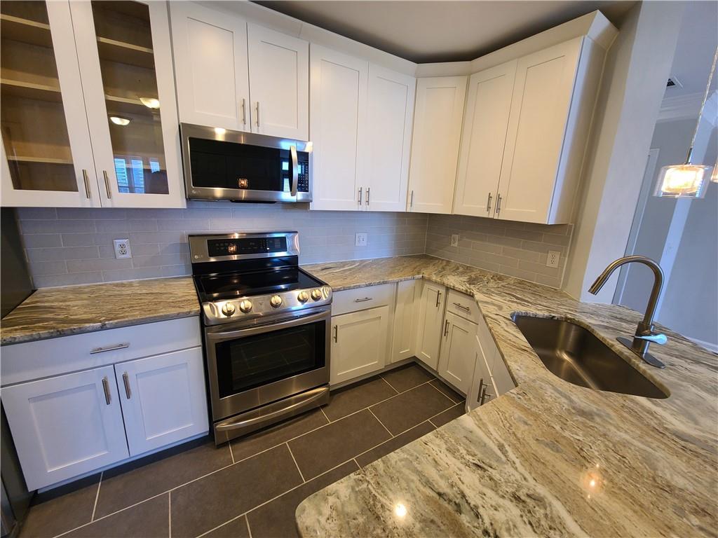 3334 Peachtree Road Northeast, Unit 910 Atlanta, GA 30326 - Photo 3 of 35 a kitchen with granite countertop a sink a stove and cabinets