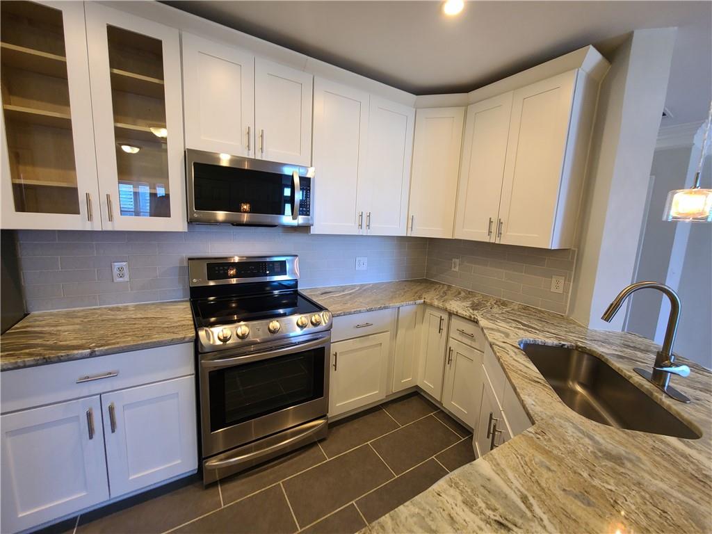 3334 Peachtree Road Northeast, Unit 910 Atlanta, GA 30326 - Photo 6 of 35 a kitchen with granite countertop a sink and a stove top oven