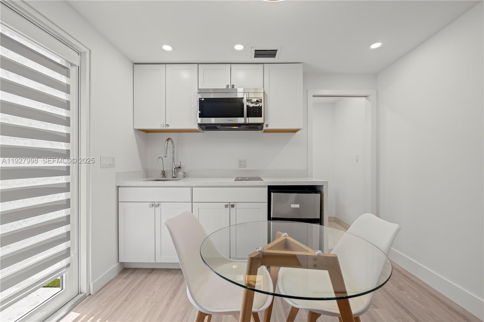 a kitchen with stainless steel appliances granite countertop a stove a sink a microwave a refrigerator and cabinets