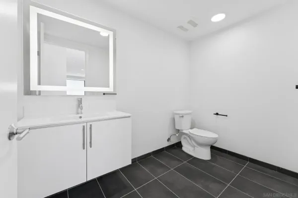 a bathroom with a sink a toilet and a mirror