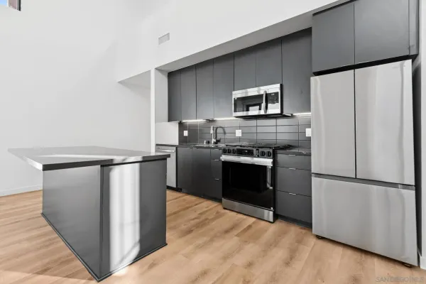 a kitchen with stainless steel appliances a refrigerator stove and microwave