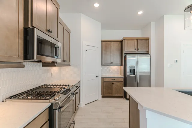 a kitchen with stainless steel appliances granite countertop a refrigerator stove and microwave