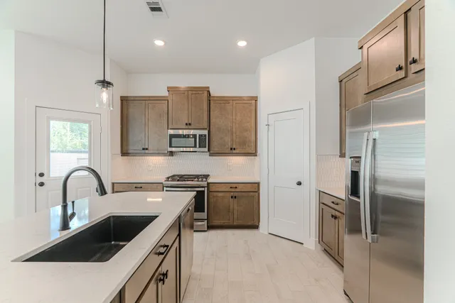 a kitchen with stainless steel appliances granite countertop a sink stove and refrigerator