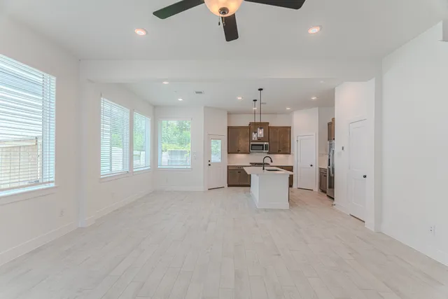 a view of a kitchen with kitchen island a sink stainless steel appliances and cabinets