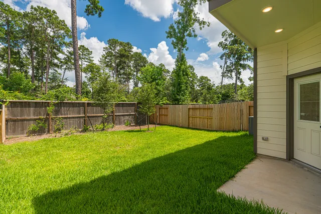 a view of an chairs and table in a backyard