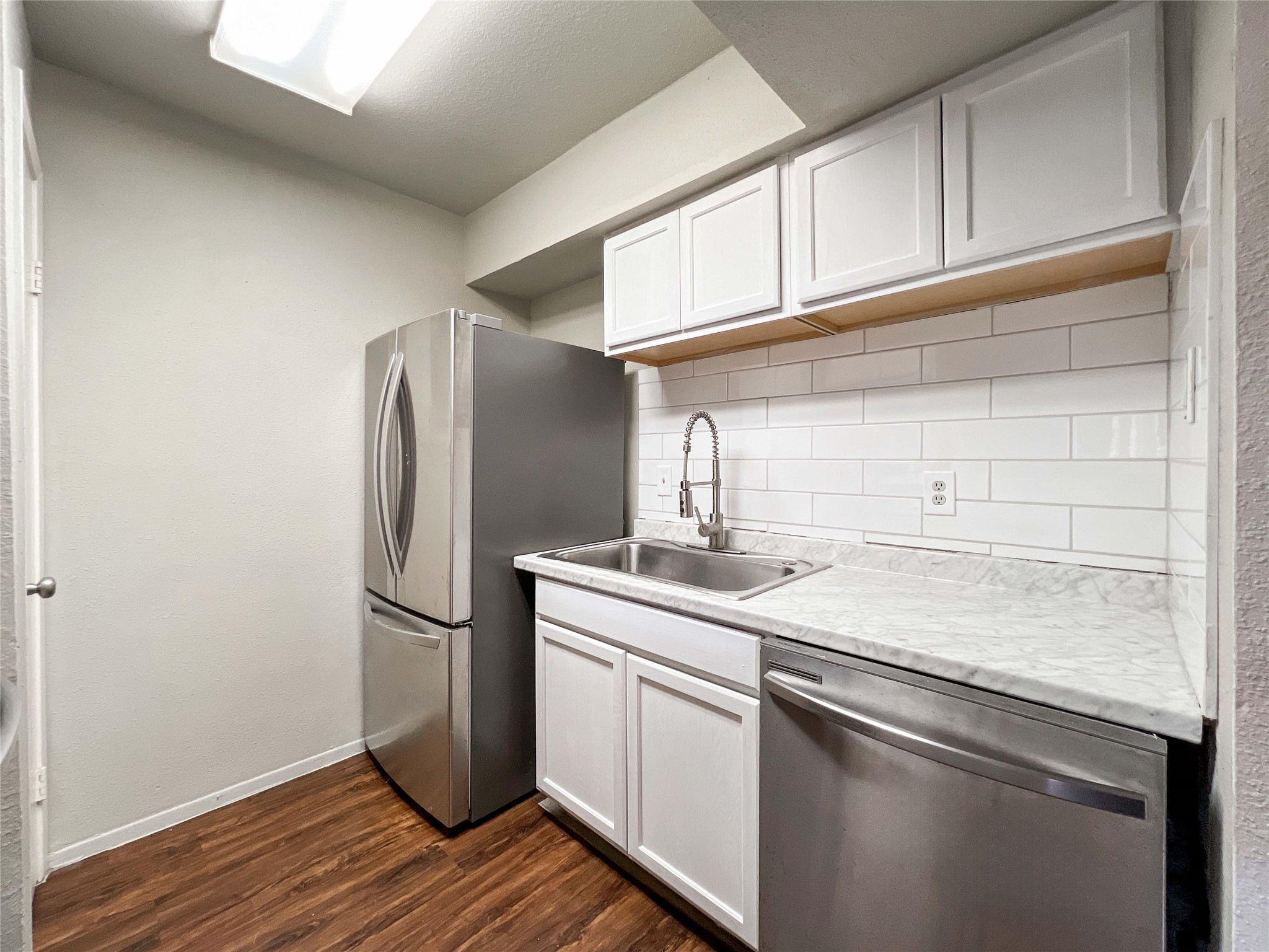 6001 Reims Road, Unit 1207 Houston, TX 77036 - Photo 4 of 18 a kitchen with stainless steel appliances granite countertop a sink and a refrigerator
