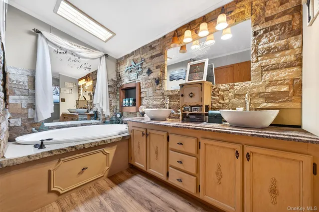 a large bathroom with a double vanity sink a mirror and a bathtub