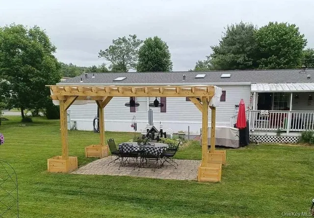 an outdoor sitting area with swimming pool and trees in the background