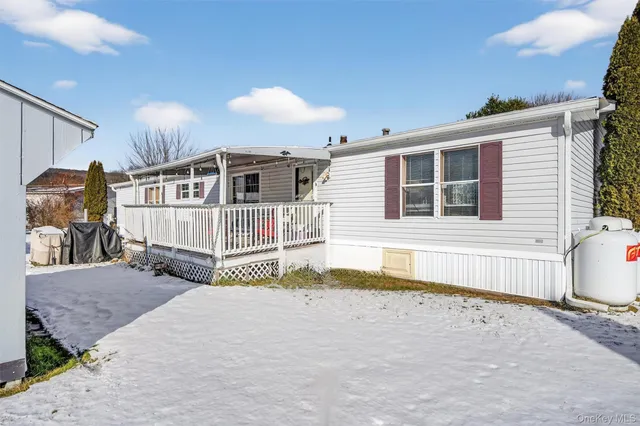 a view of a house with snow on the side of the road