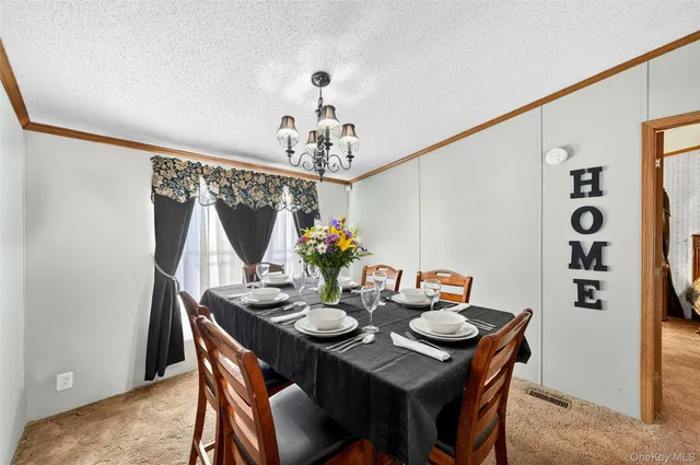 a view of a dining room with furniture and chandelier