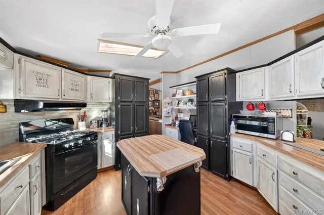 a kitchen with a sink stainless steel appliances and white cabinets
