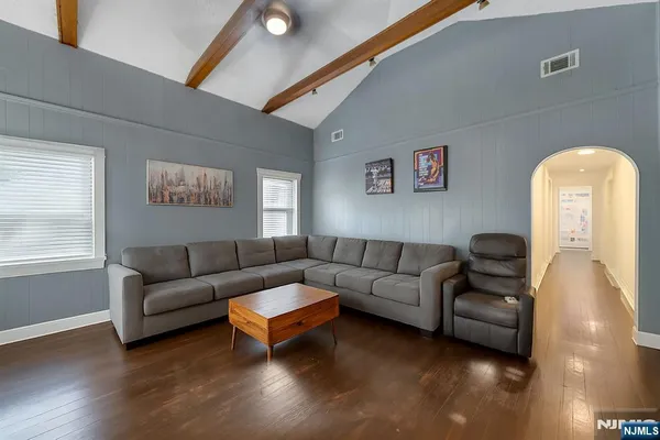 a living room with furniture and a wooden floor