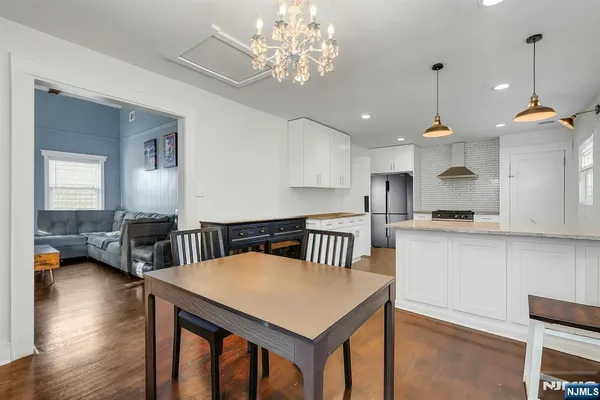 a kitchen that has a table chairs in it and wooden floors