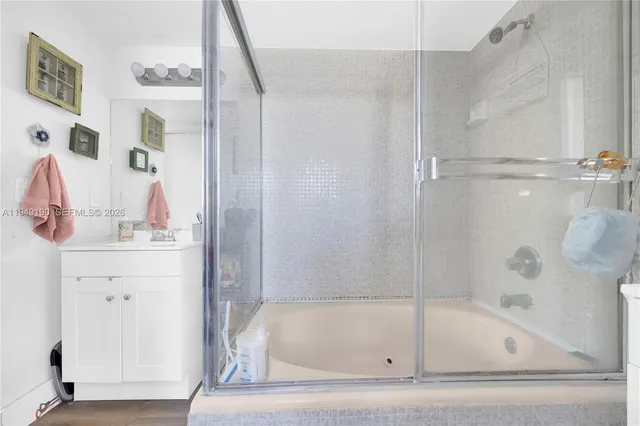 a bathroom with a tub sink and mirror