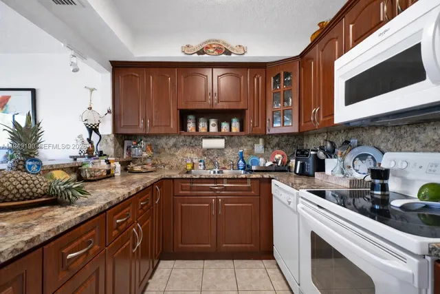 a kitchen with a sink a stove and cabinets