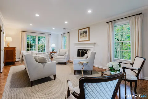 a living room with furniture fireplace and a large window